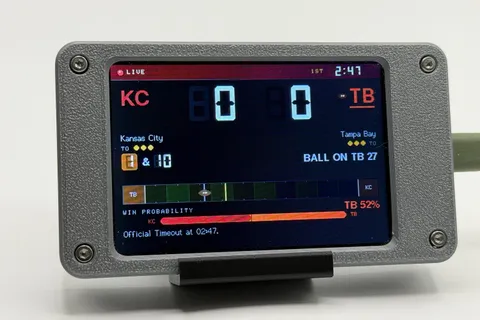 Pro Football Scoreboard in its gray case showing a game: score, quarter and clock, down and distance, a field strip and a win-probability bar.