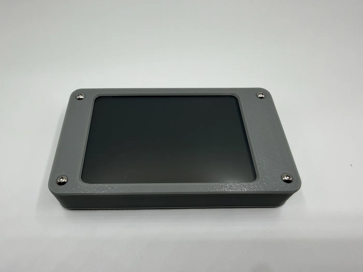 Front view of the gray 3D-printed enclosure with silver corner screws