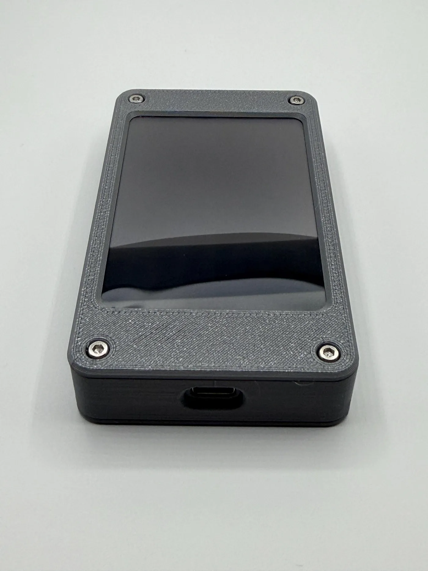 The gray 3D-printed enclosure with the USB-C port on the bottom edge